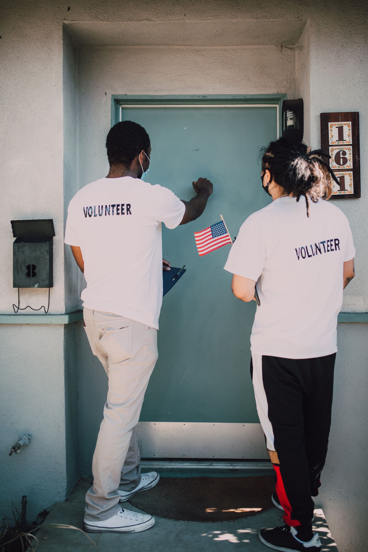 Two volunteers knocking on a neighborhood door